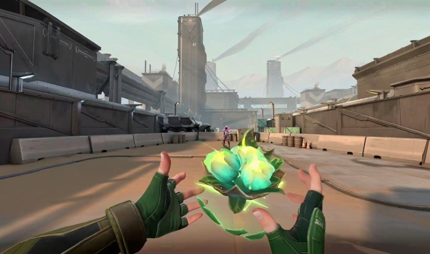First-person view in VALORANT. Green-gloved hands hold a glowing orb